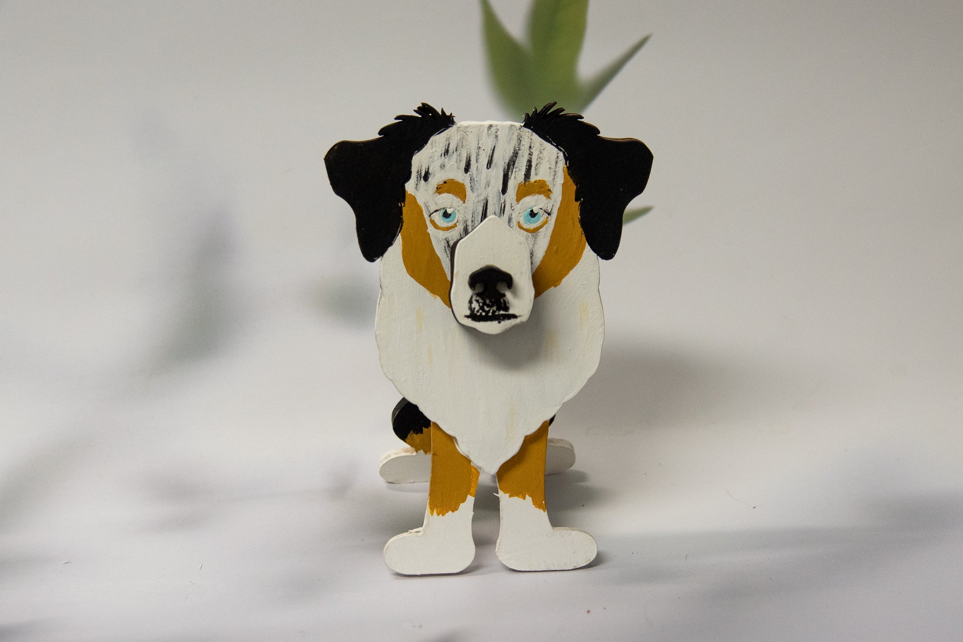 Hand-painted Australian Shepherd eyeglass holder in a sitting dog shape, available in Blue Merle, Red Merle, Black Tri, or custom colors with realistic details, designed to hold glasses on the snout. Cute and functional dog lover gift, hand-crafted and great for desks or nightstands.