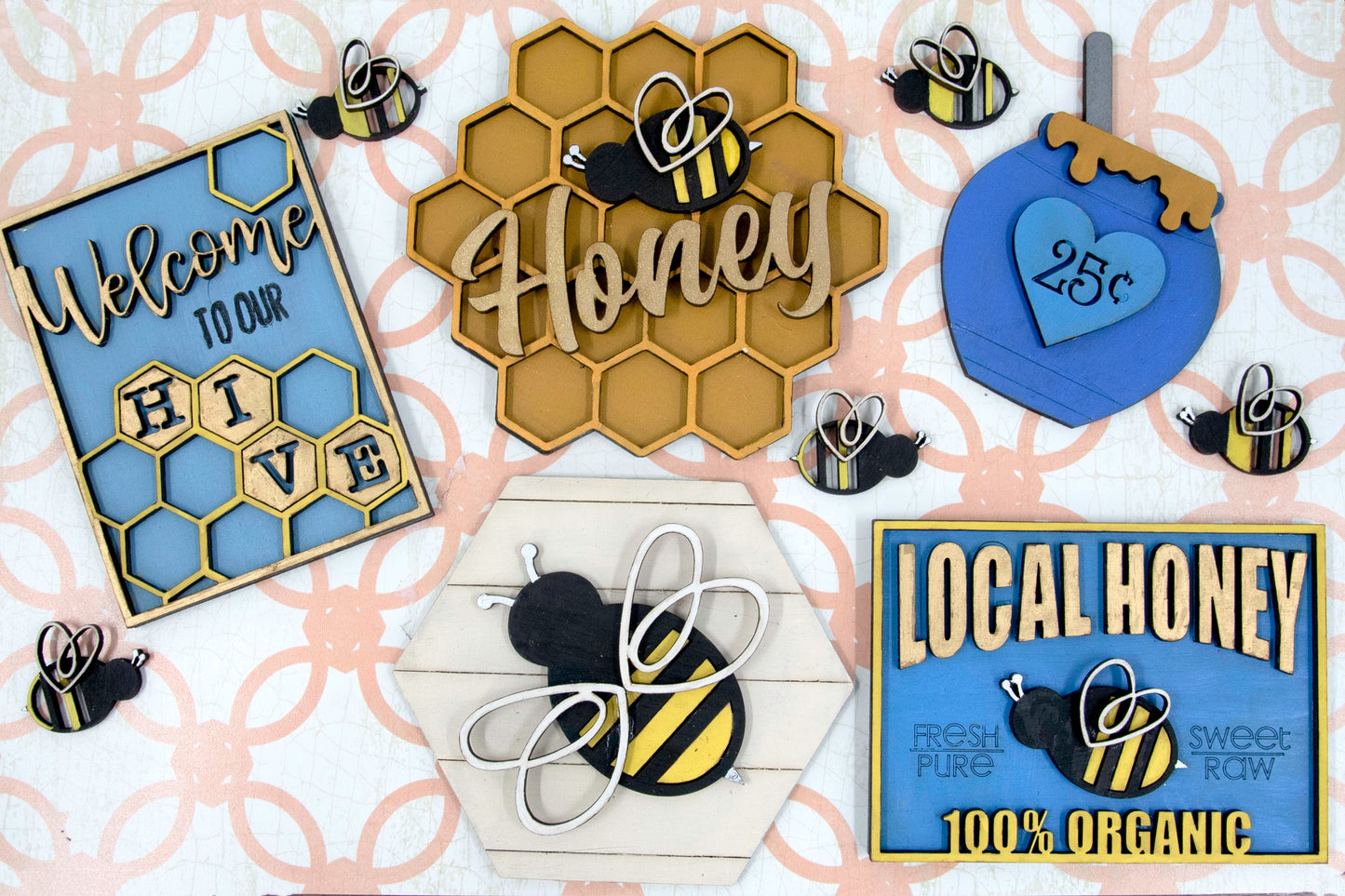 DIY bee tiered tray kit with 6 unfinished wood pieces including honey jar, local honey sign, welcome to our hive sign, honey bomb, bee hexagon plaque, and 5 small bee accents. Ideal for painting, staining, and customizing. Comes with stands for easy display. Perfect for summer crafts, farmhouse style decor, or paint-your-own projects. Great for hobby crafters, DIY parties, and seasonal decorating fun with a bee and honey theme.
