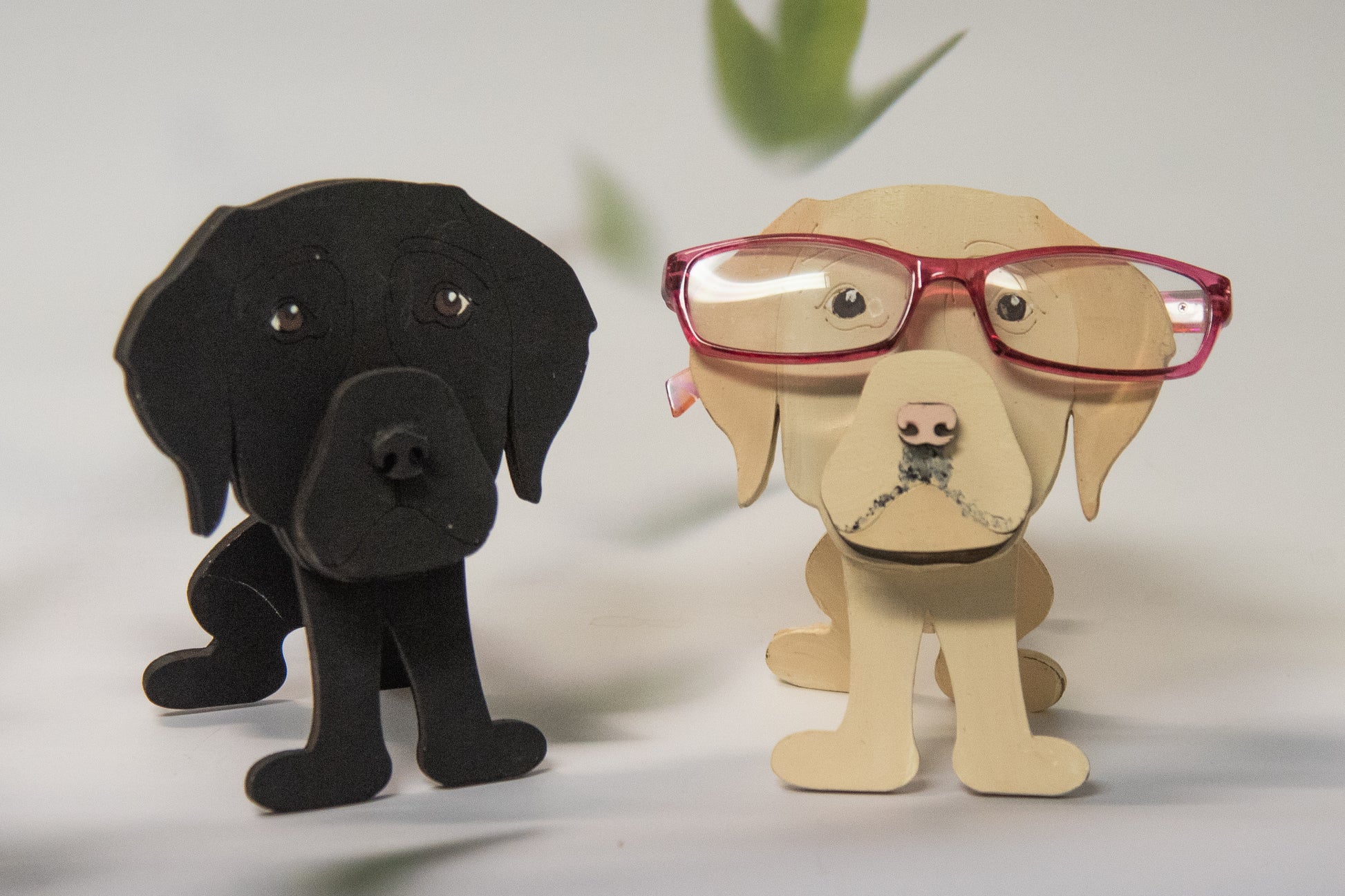 Custom handmade glasses holder shaped like a black and yellow Labrador Retriever, designed to hold eyeglasses or sunglasses. Features include a wooden build, optional DIY kit for paint-your-own fun, and an engraved nameplate for personalization. Shown assembled and with DIY parts, this functional and decorative dog-shaped