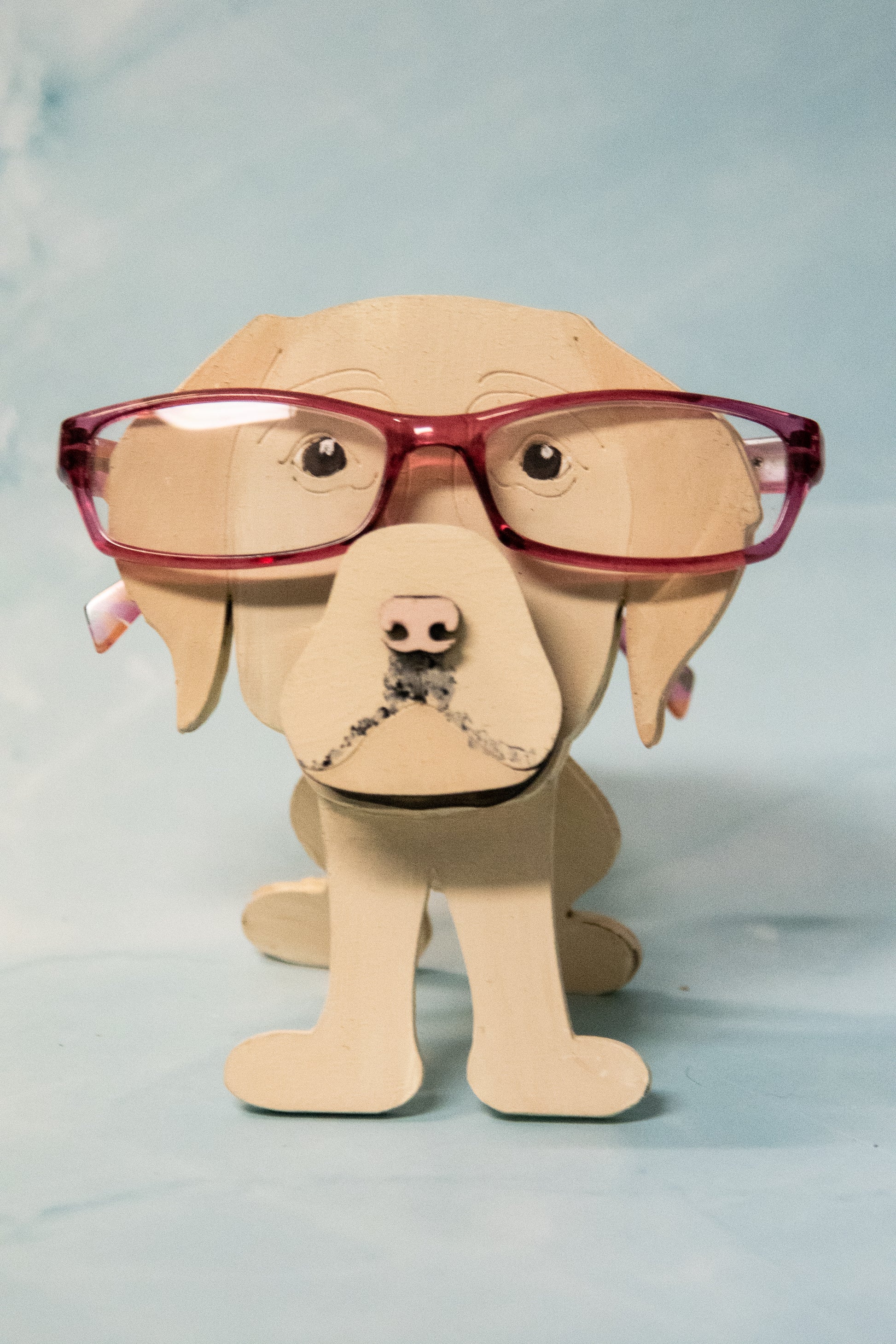 Custom handmade glasses holder shaped like a black and yellow Labrador Retriever, designed to hold eyeglasses or sunglasses. Features include a wooden build, optional DIY kit for paint-your-own fun, and an engraved nameplate for personalization. Shown assembled and with DIY parts, this functional and decorative dog-shaped