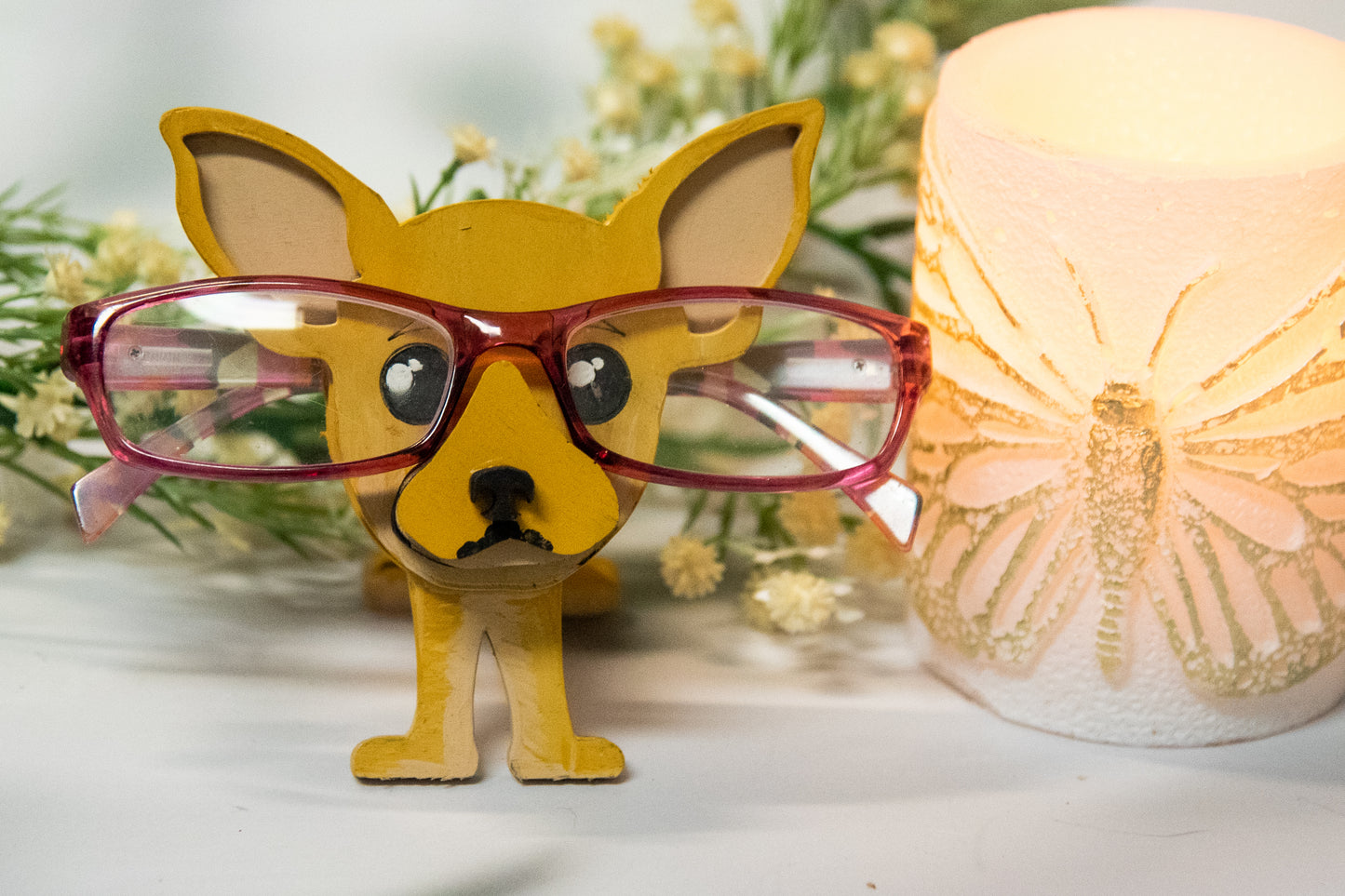 Hand-painted wooden chihuahua glasses holder shaped like a small standing dog, designed to hold eyeglasses securely on its nose. Features custom-painted colors like black, tan, or white. Functional dog decor that works as an eyeglass organizer for pet lovers, dog moms, or anyone who adores their chihuahua. Made from wood and painted by hand with charming detail, ideal for display on desks, nightstands, or bookshelves.