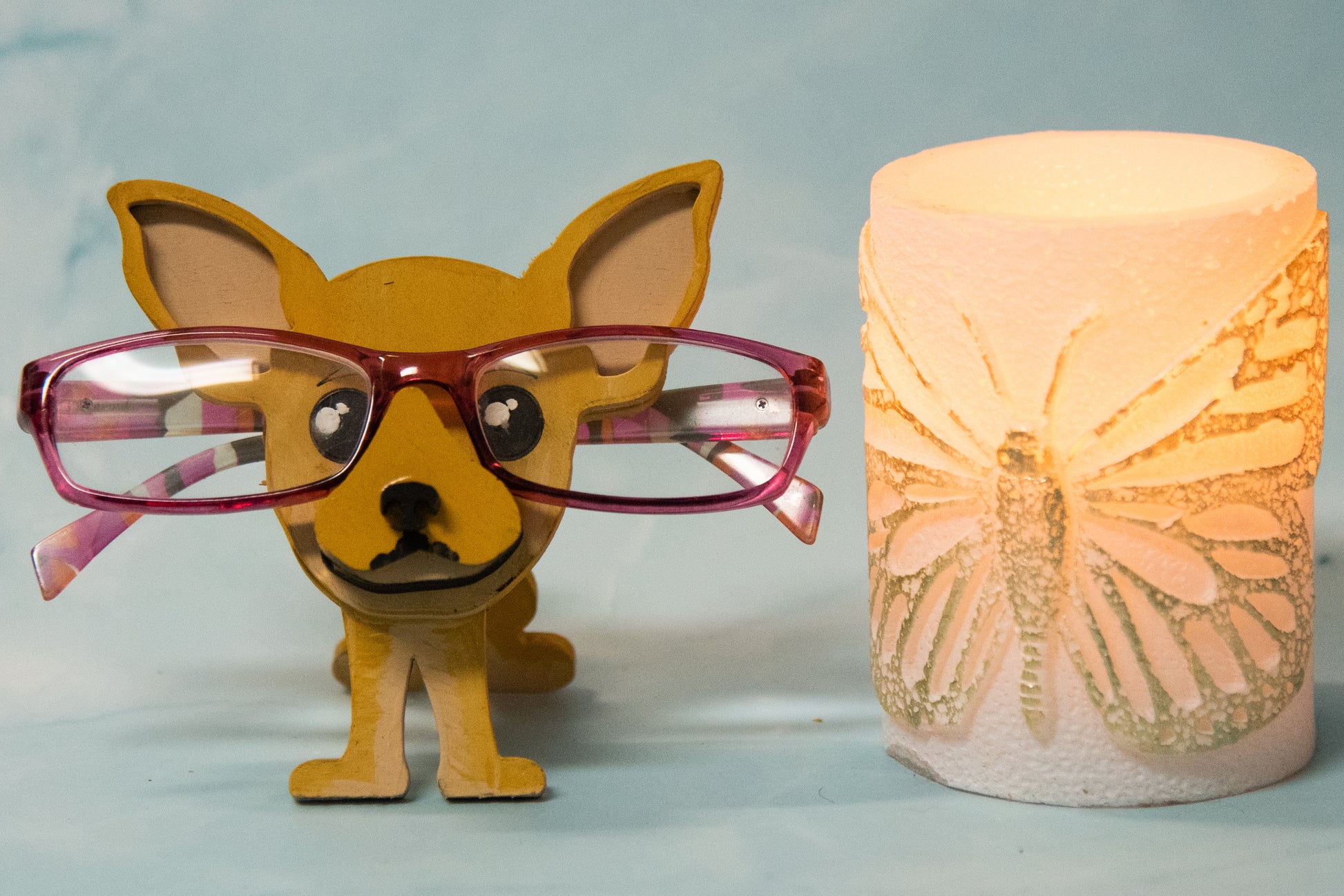 Hand-painted wooden chihuahua glasses holder shaped like a small standing dog, designed to hold eyeglasses securely on its nose. Features custom-painted colors like black, tan, or white. Functional dog decor that works as an eyeglass organizer for pet lovers, dog moms, or anyone who adores their chihuahua. Made from wood and painted by hand with charming detail, ideal for display on desks, nightstands, or bookshelves.