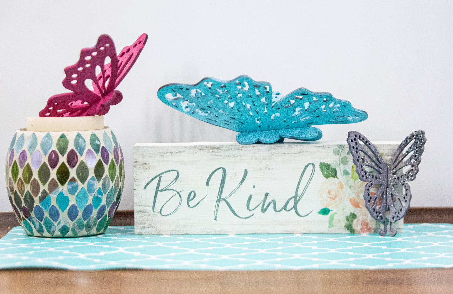 Finished 3D butterfly shelf sitter with two layers of wood, patterned top layer, hand painted in custom colors, standing on a shelf or tray as whimsical spring or seasonal decor accent.