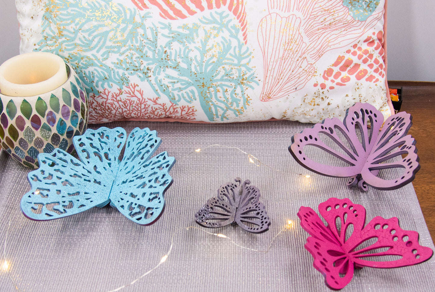 Finished 3D butterfly shelf sitter with two layers of wood, patterned top layer, hand painted in custom colors, standing on a shelf or tray as whimsical spring or seasonal decor accent.