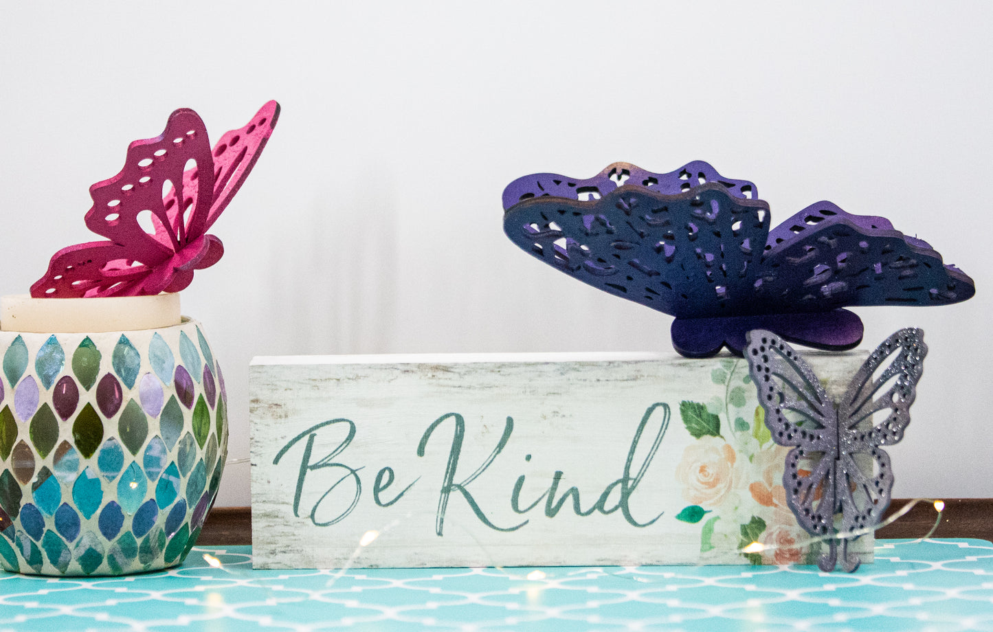 Finished 3D butterfly shelf sitter with two layers of wood, patterned top layer, hand painted in custom colors, standing on a shelf or tray as whimsical spring or seasonal decor accent.