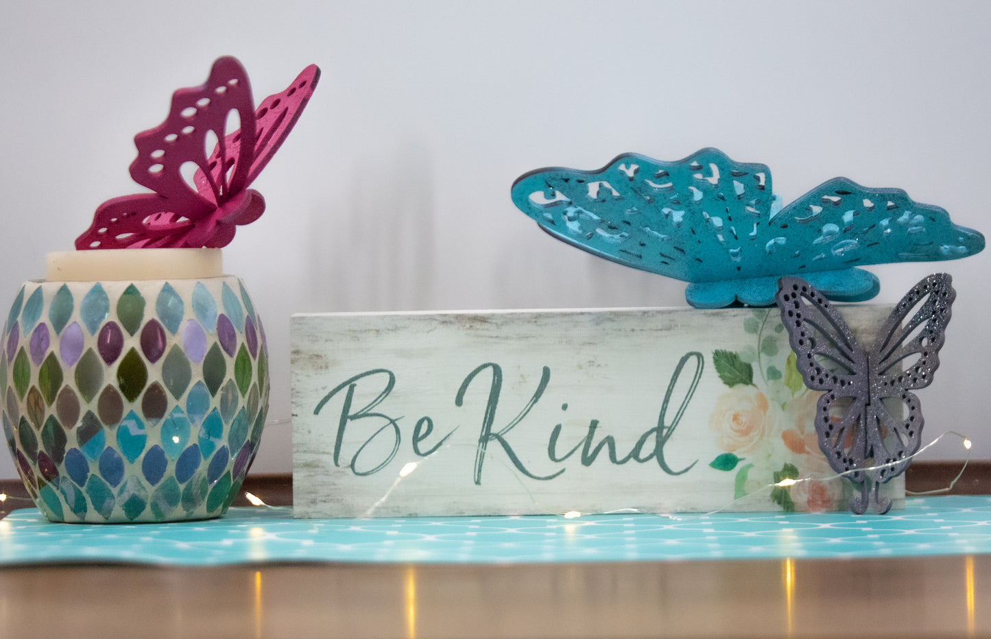 Finished 3D butterfly shelf sitter with two layers of wood, patterned top layer, hand painted in custom colors, standing on a shelf or tray as whimsical spring or seasonal decor accent.