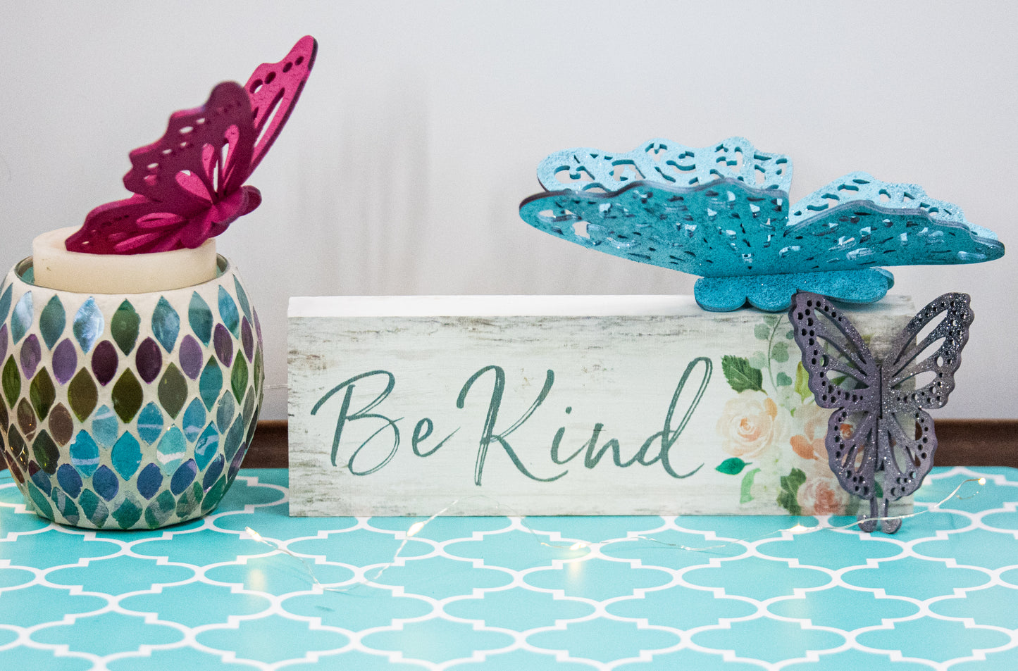 Finished 3D butterfly shelf sitter with two layers of wood, patterned top layer, hand painted in custom colors, standing on a shelf or tray as whimsical spring or seasonal decor accent.