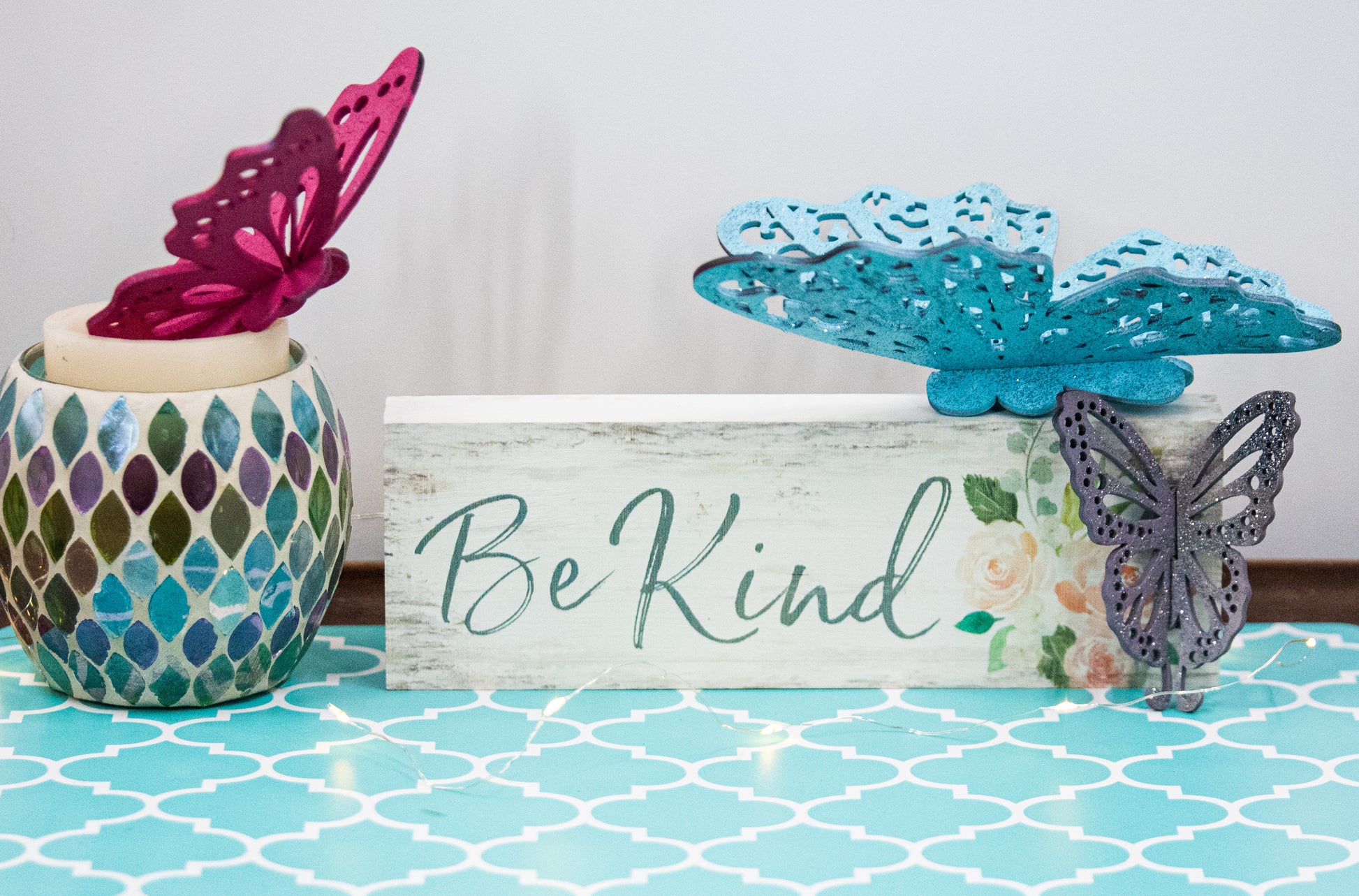 Finished 3D butterfly shelf sitter with two layers of wood, patterned top layer, hand painted in custom colors, standing on a shelf or tray as whimsical spring or seasonal decor accent.