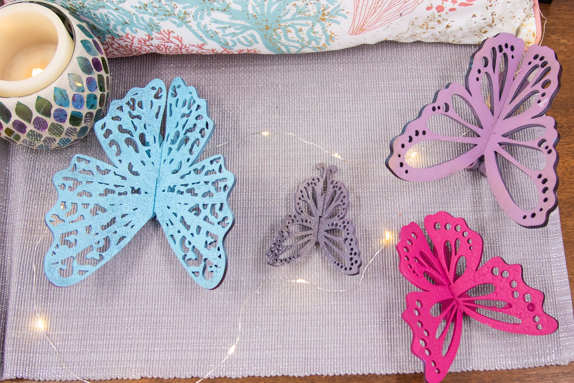 Finished 3D butterfly shelf sitter with two layers of wood, patterned top layer, hand painted in custom colors, standing on a shelf or tray as whimsical spring or seasonal decor accent.