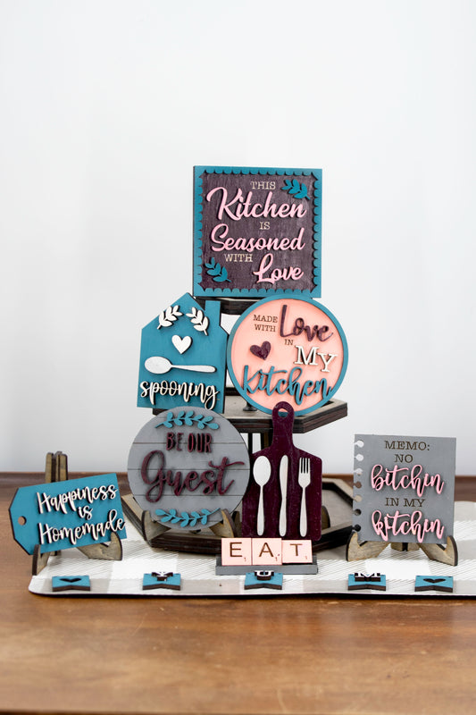 Unpainted DIY kitchen tiered tray decor kit with wood signs, “Eat” scrabble tiles, utensil cutouts, and mini banners, perfect for personalizing your kitchen space with your own paint and style.