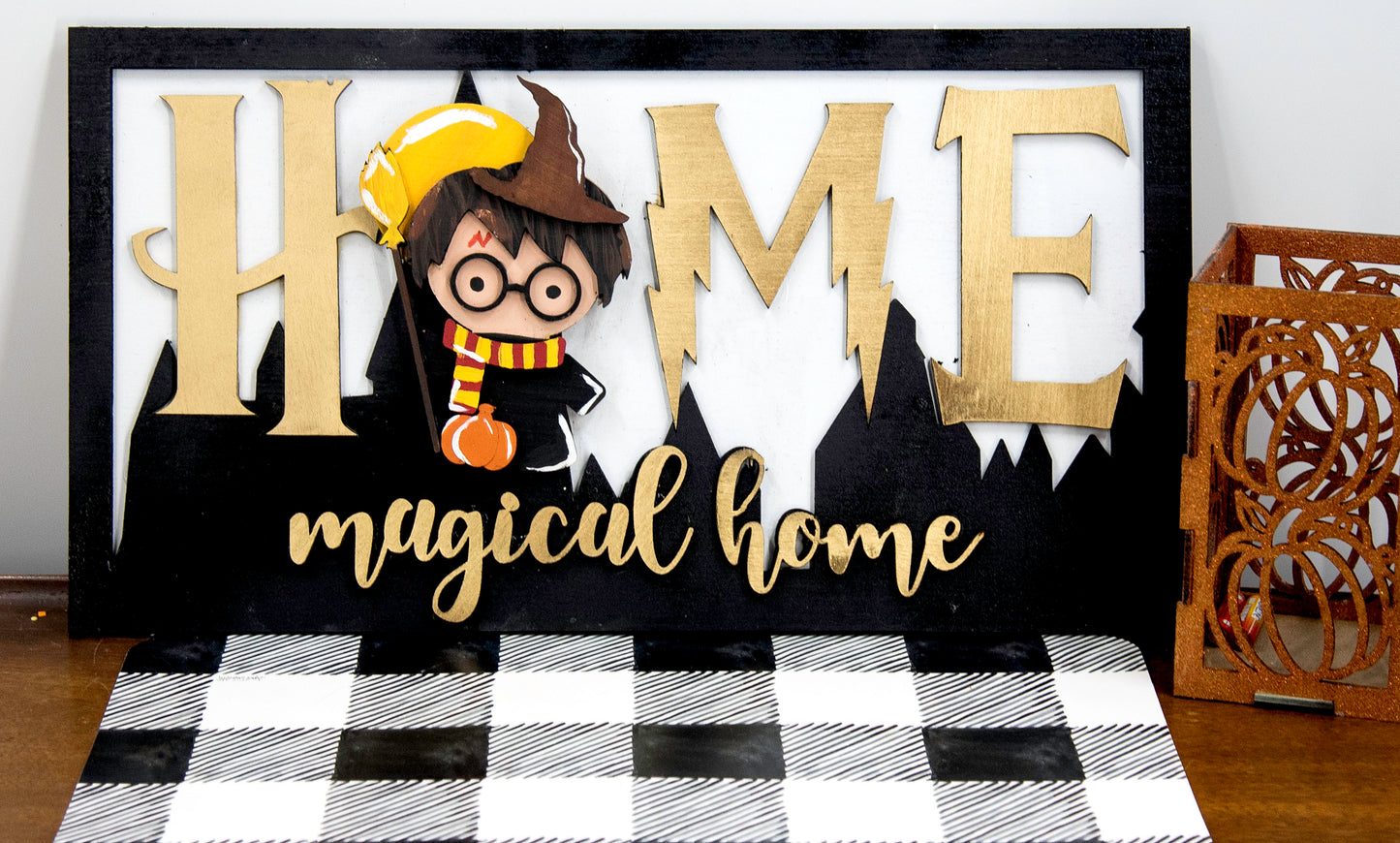 Full view of handcrafted wizard-themed interchangeable wooden sign that reads 'Home Magical Home' with wizard silhouettes forming the letter O, displayed on a shelf with all 12 hand-painted seasonal pieces including pumpkin, snowflake, shamrock, heart, sun, watermelon, leaf, ornament, egg, flower, flag, and candy corn — perfect for year-round magical home decor, Harry Potter-inspired, fantasy cottagecore aesthetic, unique seasonal gift for wizard fans and DIY crafters