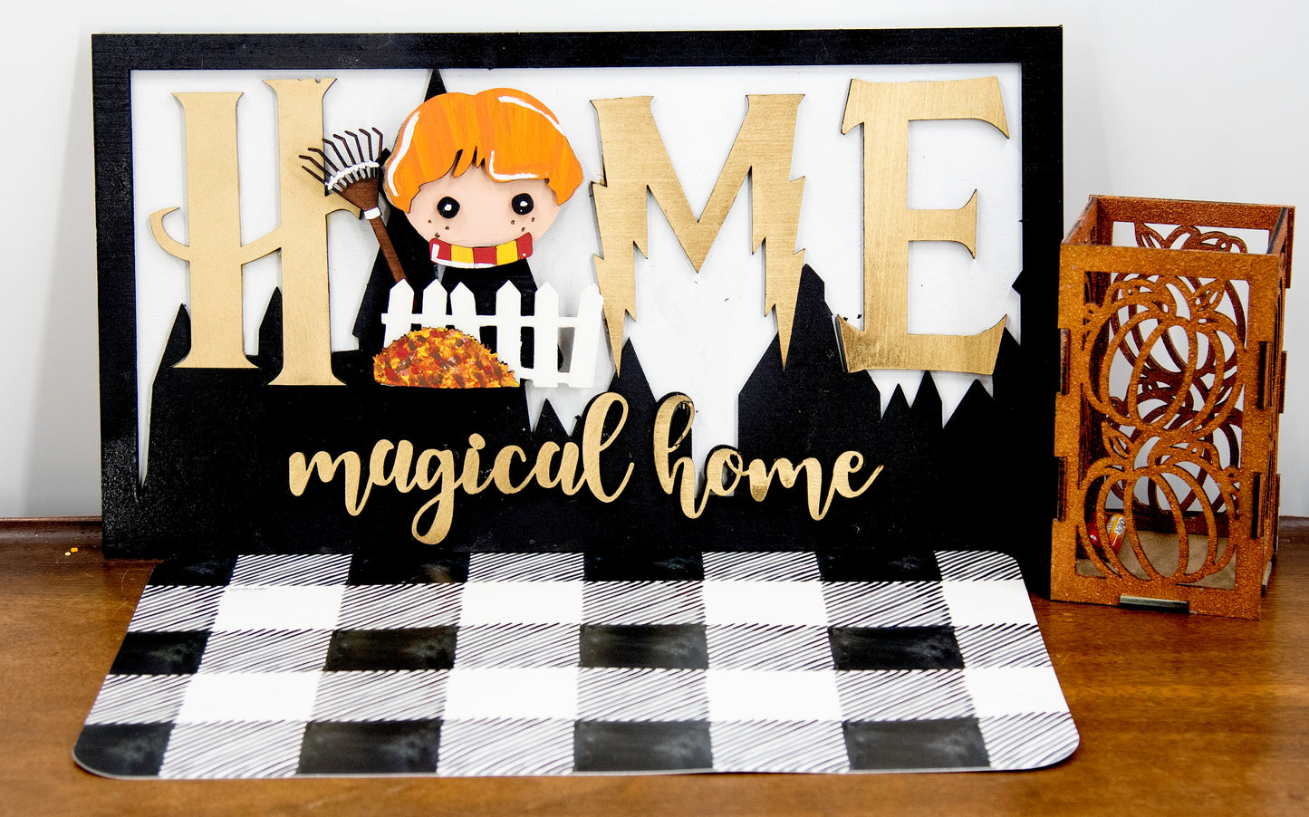Full view of handcrafted wizard-themed interchangeable wooden sign that reads 'Home Magical Home' with wizard silhouettes forming the letter O, displayed on a shelf with all 12 hand-painted seasonal pieces including pumpkin, snowflake, shamrock, heart, sun, watermelon, leaf, ornament, egg, flower, flag, and candy corn — perfect for year-round magical home decor, Harry Potter-inspired, fantasy cottagecore aesthetic, unique seasonal gift for wizard fans and DIY crafters