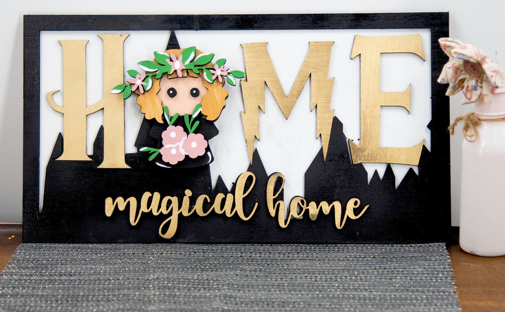 Full view of handcrafted wizard-themed interchangeable wooden sign that reads 'Home Magical Home' with wizard silhouettes forming the letter O, displayed on a shelf with all 12 hand-painted seasonal pieces including pumpkin, snowflake, shamrock, heart, sun, watermelon, leaf, ornament, egg, flower, flag, and candy corn — perfect for year-round magical home decor, Harry Potter-inspired, fantasy cottagecore aesthetic, unique seasonal gift for wizard fans and DIY crafters