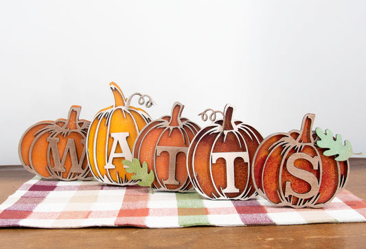 Custom standing wood pumpkins designed as individual letters to spell out names, fall words, or seasonal phrases. Each letter is crafted into a 3D pumpkin shape with intricate etched details, layered for dimension, and hand-painted in your choice of autumn colors. These personalized shelf sitters range in size from 3 to 6.5 inches and are perfect for mantels, entry tables, tiered trays, classrooms, or Thanksgiving displays. Ideal for gifting or adding a festive touch to your home.
