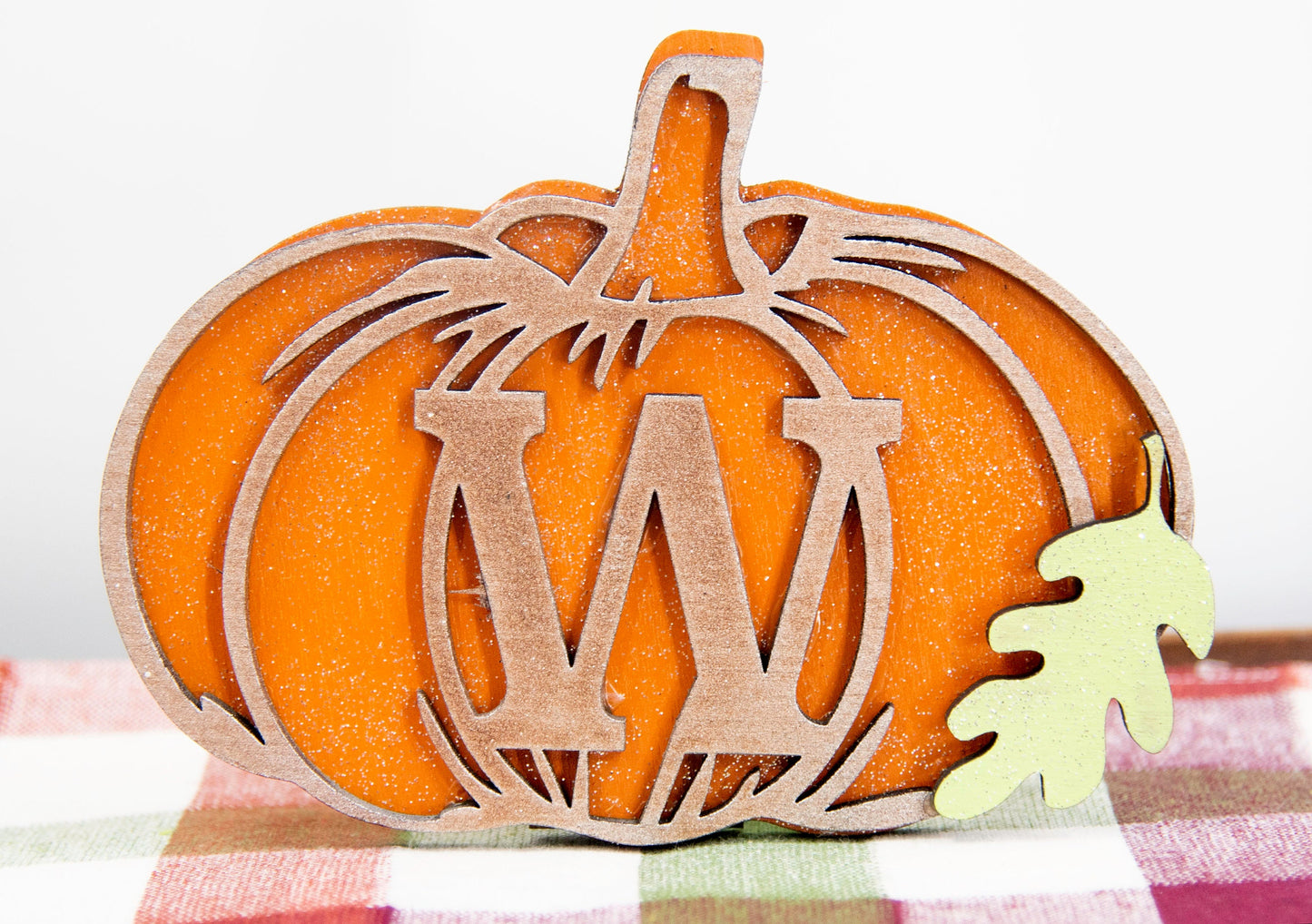 Custom standing wood pumpkins designed as individual letters to spell out names, fall words, or seasonal phrases. Each letter is crafted into a 3D pumpkin shape with intricate etched details, layered for dimension, and hand-painted in your choice of autumn colors. These personalized shelf sitters range in size from 3 to 6.5 inches and are perfect for mantels, entry tables, tiered trays, classrooms, or Thanksgiving displays. Ideal for gifting or adding a festive touch to your home.
