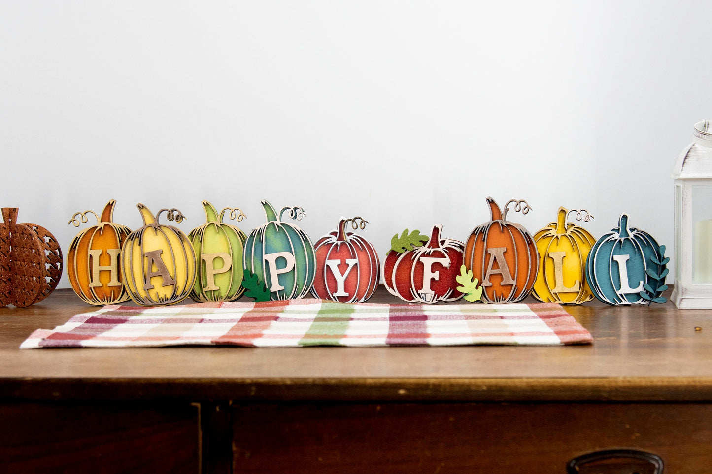 Custom standing wood pumpkins designed as individual letters to spell out names, fall words, or seasonal phrases. Each letter is crafted into a 3D pumpkin shape with intricate etched details, layered for dimension, and hand-painted in your choice of autumn colors. These personalized shelf sitters range in size from 3 to 6.5 inches and are perfect for mantels, entry tables, tiered trays, classrooms, or Thanksgiving displays. Ideal for gifting or adding a festive touch to your home.
